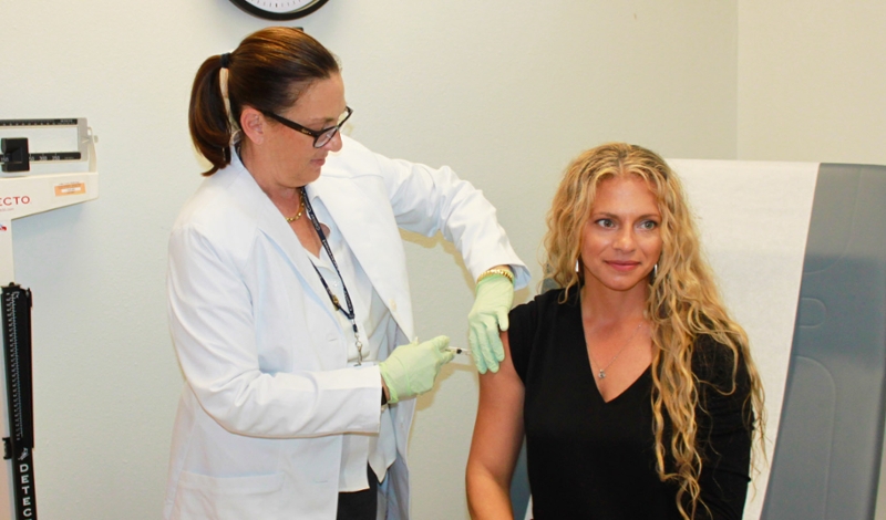 Woman getting a FLU shot by nurse