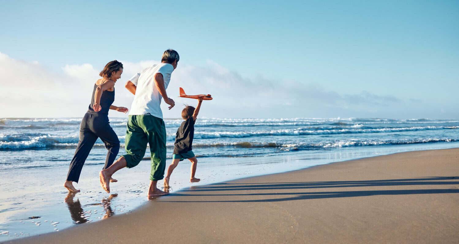 Family of three running on the beach
